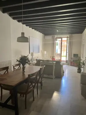 a dining room and living room with a table and chairs at Jardin Bizcocheros in Jerez de la Frontera