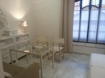 a living room with a glass table and chairs at Jardin Bizcocheros in Jerez de la Frontera