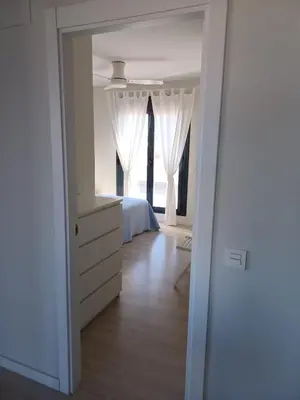 a bedroom with a bed and a dresser and a window at Atico Costa Doñana in Sanlúcar de Barrameda