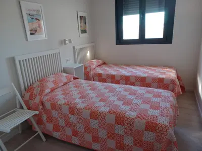 a bedroom with two beds and a window at Atico Costa Doñana in Sanlúcar de Barrameda