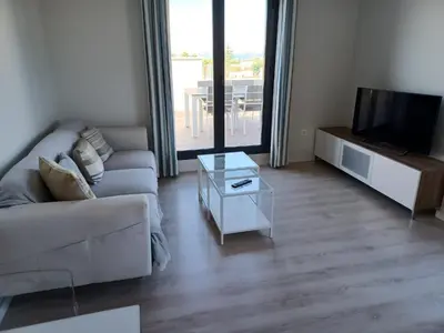 a living room with a couch and a tv at Atico Costa Doñana in Sanlúcar de Barrameda