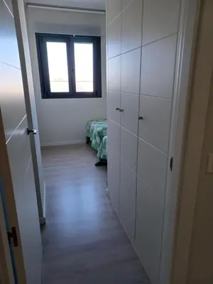 a room with white cabinets and a bed in it at Atico Costa Doñana in Sanlúcar de Barrameda