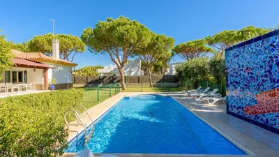 a swimming pool in a yard with trees and a house at Villa con Encanto Conil de la Frontera by Ruralidays in Conil de la Frontera