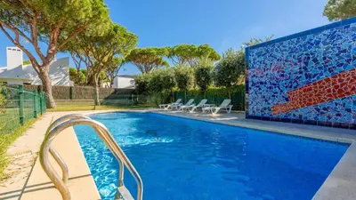 a swimming pool with chairs and a tile wall at Villa con Encanto Conil de la Frontera by Ruralidays in Conil de la Frontera