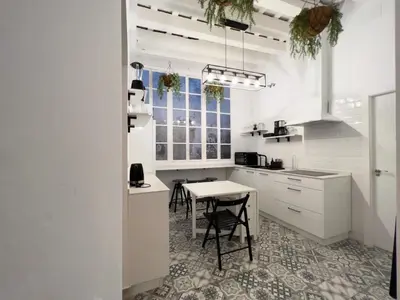 a white kitchen with a table and chairs at El Destino Corazón de Cádiz Grupo AC Gestion in Cádiz