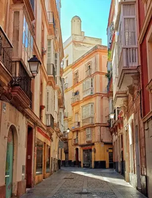 an empty street in an alley between buildings at El Destino Corazón de Cádiz Grupo AC Gestion in Cádiz