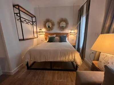 a bedroom with a bed with two pillows and a mirror at Loft Deluxe Herrería 6 - Vivienda Vacacional. in El Puerto de Santa María