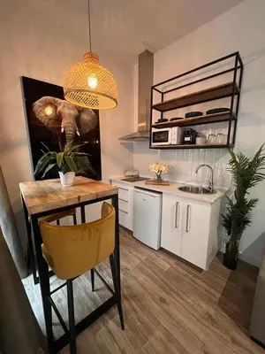 a kitchen with a table and a sink and a dining room at Loft Deluxe Herrería 6 - Vivienda Vacacional. in El Puerto de Santa María