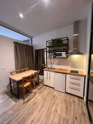 a kitchen with a table and a dining room at Loft Deluxe Herrería 6 - Vivienda Vacacional. in El Puerto de Santa María