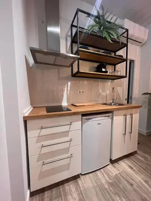 a kitchen with white cabinets and a sink at Loft Deluxe Herrería 6 - Vivienda Vacacional. in El Puerto de Santa María