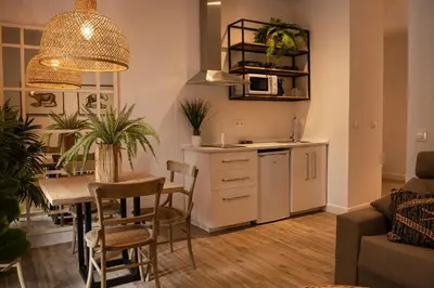 a living room with a kitchen and a table with a dining room at Loft Deluxe Herrería 6 - Vivienda Vacacional. in El Puerto de Santa María