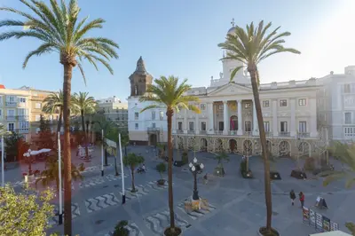 a large building with palm trees in front of it at SERENISSIMA Apartment by Cadiz4Rentals in Cádiz