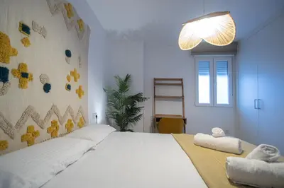 a bedroom with a large white bed with towels on it at Apartamento La Habanera de Cadiz in Cádiz