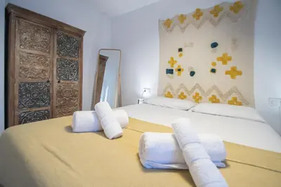 a bedroom with a large bed with white towels on it at Apartamento La Habanera de Cadiz in Cádiz
