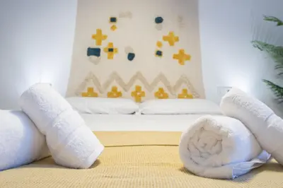 a bed with rolled up towels on top of it at Apartamento La Habanera de Cadiz in Cádiz