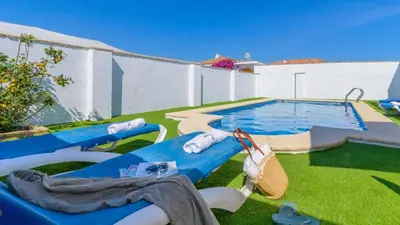 a backyard with a swimming pool and some chairs and a swimming pool at Villa Brenda Conil de la Frontera by Ruralidays in Conil de la Frontera