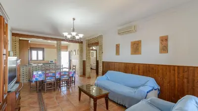a large kitchen with wooden cabinets and a microwave at Villa Brenda Conil de la Frontera by Ruralidays in Conil de la Frontera