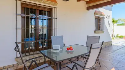 an outdoor kitchen with a stone fireplace in a house at Villa Brenda Conil de la Frontera by Ruralidays in Conil de la Frontera