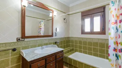 a bathroom with a sink and a bath tub and a mirror at Villa Brenda Conil de la Frontera by Ruralidays in Conil de la Frontera
