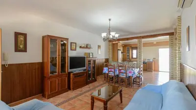 a living room with a blue couch and a tv at Villa Brenda Conil de la Frontera by Ruralidays in Conil de la Frontera