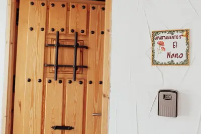 a wooden door with a sign on a wall at APARTAMENTO EL NANO in Jerez de la Frontera