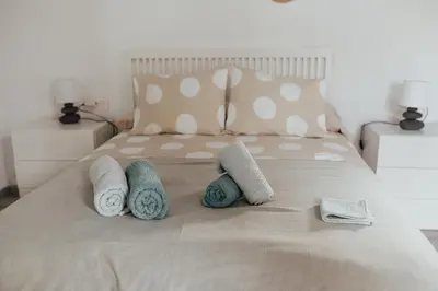 a bed with pillows and towels on it at APARTAMENTO EL NANO in Jerez de la Frontera