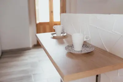 two coffee cups on a wooden table in a room at APARTAMENTO EL NANO in Jerez de la Frontera