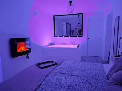 a purple room with a tub and a fireplace at Amores Loft Rural in Alcalá de los Gazules