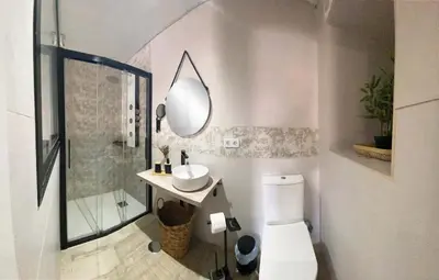 a bathroom with a toilet and a sink and a mirror at Amores Loft Rural in Alcalá de los Gazules