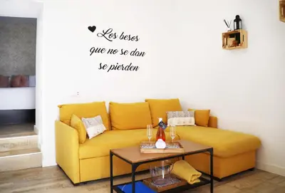 a yellow couch in a living room with a table at Amores Loft Rural in Alcalá de los Gazules