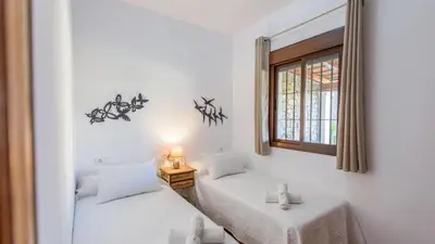 a room with two beds and a window at Apto El Descanso I Conil de la Frontera by Ruralidays in Conil de la Frontera