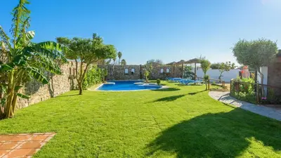 a backyard with a swimming pool and a grass yard at Apto El Descanso I Conil de la Frontera by Ruralidays in Conil de la Frontera