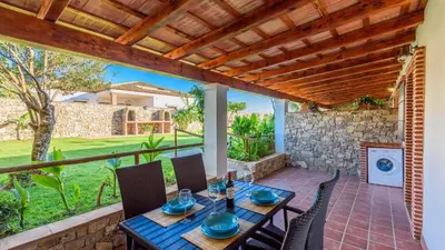 a patio with a table and chairs and a stone wall at Apto El Descanso I Conil de la Frontera by Ruralidays in Conil de la Frontera