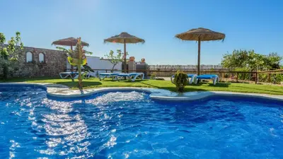 a swimming pool with umbrellas in a yard at Apto El Descanso I Conil de la Frontera by Ruralidays in Conil de la Frontera