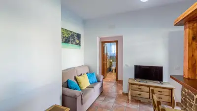 a living room with a couch and a tv at Apto El Descanso I Conil de la Frontera by Ruralidays in Conil de la Frontera
