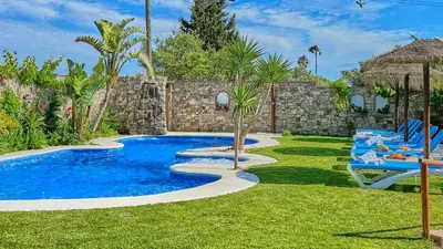 a swimming pool in a yard with blue lounge chairs at Apto El Descanso III Conil de la Frontera by Ruralidays in Conil de la Frontera