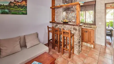 a living room with a couch and a stone fireplace at Apto El Descanso III Conil de la Frontera by Ruralidays in Conil de la Frontera