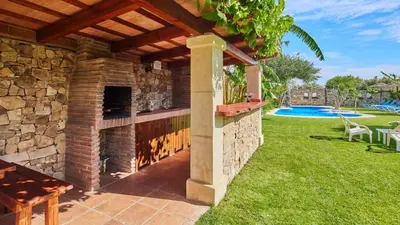 a patio with a stone fireplace in a yard at Apto El Descanso III Conil de la Frontera by Ruralidays in Conil de la Frontera