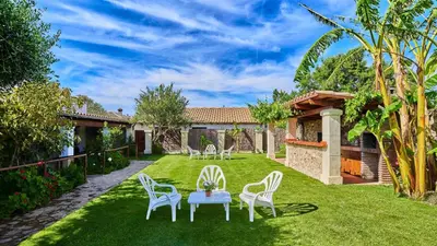 a garden with a table and chairs and a house at Apto El Descanso III Conil de la Frontera by Ruralidays in Conil de la Frontera