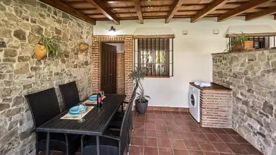 a patio with a table and chairs and a brick wall at Apto El Descanso III Conil de la Frontera by Ruralidays in Conil de la Frontera