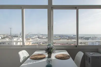 a white table with a vase of flowers on it at Apartamento La Atalaya de Cádiz in Cádiz
