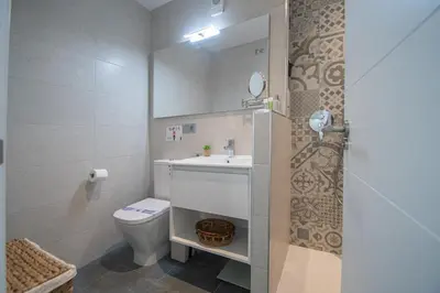 a bathroom with a toilet and a sink and a mirror at Apartamento La Atalaya de Cádiz in Cádiz