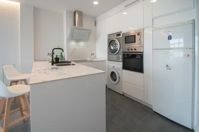 a kitchen with white cabinets and a refrigerator at Apartamento La Atalaya de Cádiz in Cádiz
