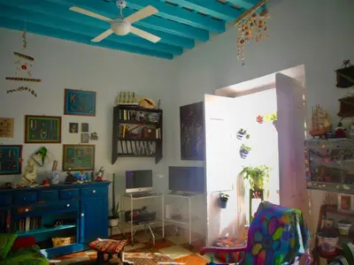 a living room with a ceiling fan and a window at Habitaciones La Pepa in Cádiz
