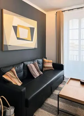 a black leather couch in a living room at Casa Odisea Cádiz in Cádiz