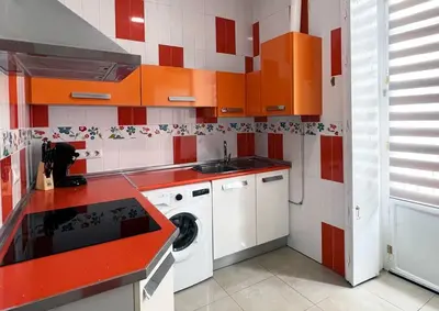 a red and white kitchen with a washing machine at Casa Odisea Cádiz in Cádiz