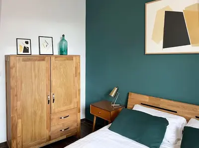 a bedroom with a bed and a wooden cabinet at Casa Odisea Cádiz in Cádiz