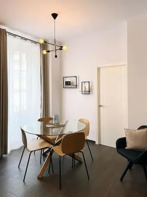 a dining room with a glass table and chairs at Casa Odisea Cádiz in Cádiz