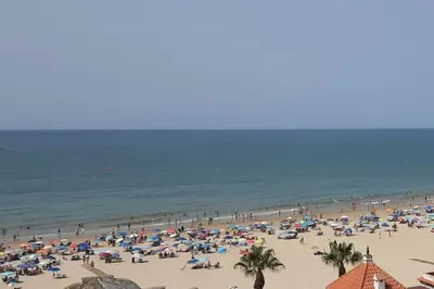 a group of people on a beach with the ocean at Luz, sol y arena in Rota