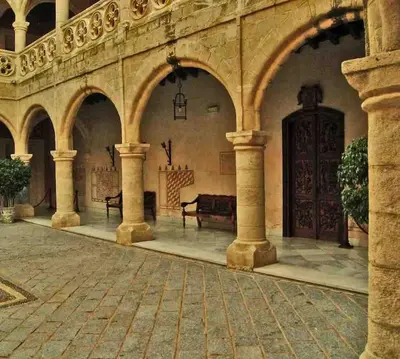 an empty courtyard with two benches in a building at Luz, sol y arena in Rota